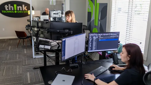 Lauren and a teammate at their workstations in the thinkVoIP office