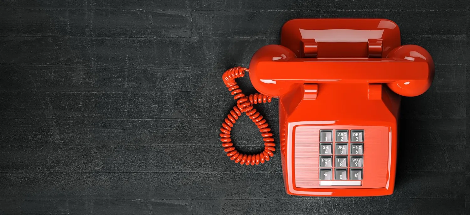 Red vintage telephone on dark background