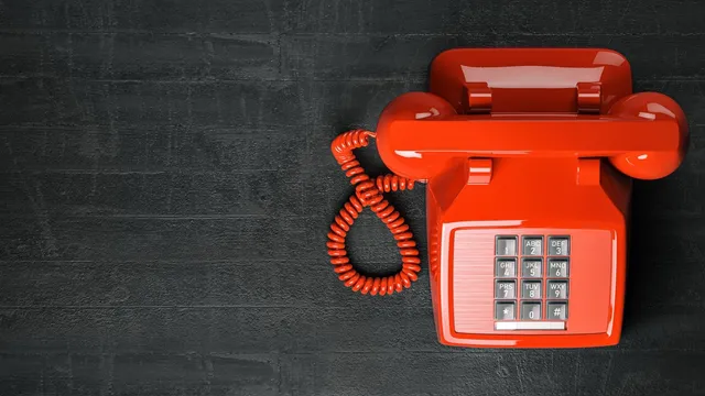 Red vintage telephone on dark background