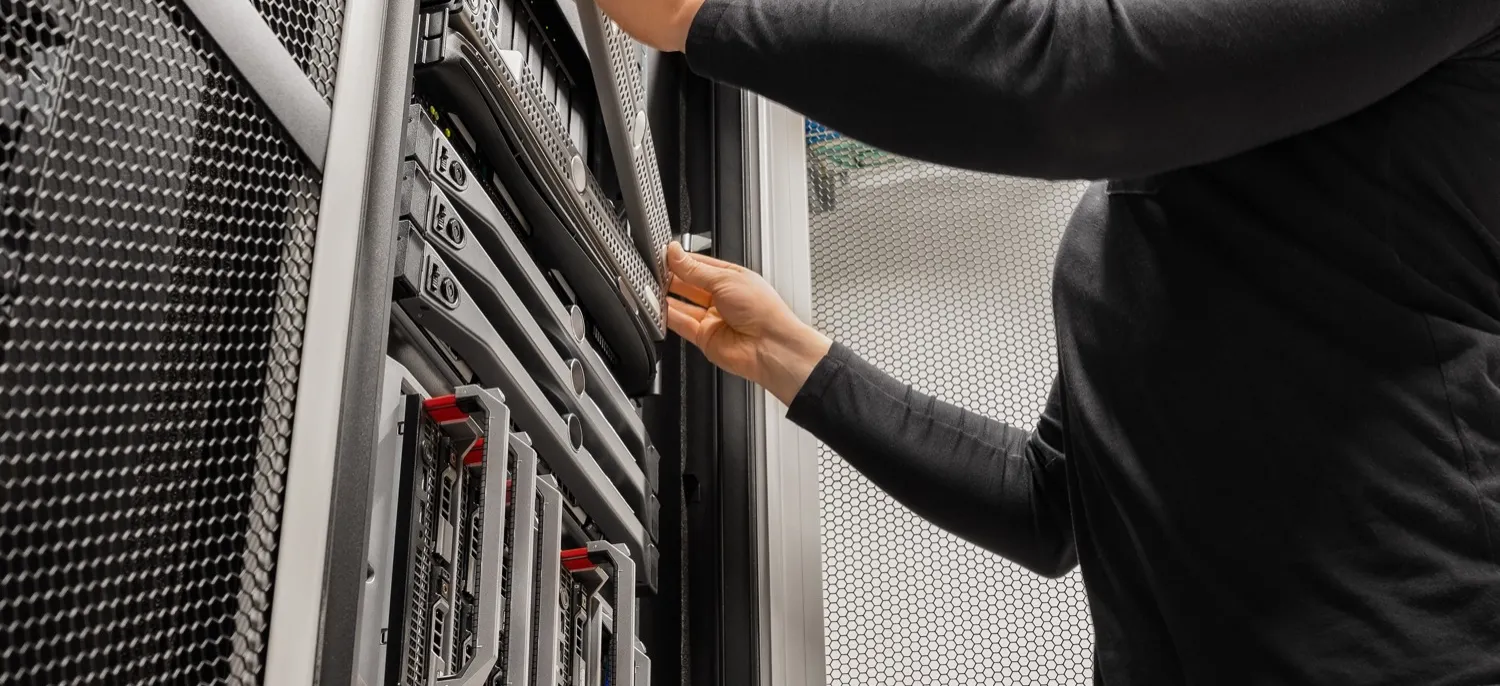 Technician working on server rack equipment in a data closet